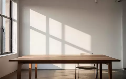 Ein minimalistischer, moderner Arbeitsbereich in einem kreativen Studio mit leerem Holztisch und natürlichem Licht. - Foto: über boerse-global.de
