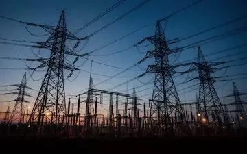 Hochspannungsmasten einer elektrischen Schaltanlage vor einem blauen Abendhimmel als Symbol für kritische Infrastruktur. - Foto: über boerse-global.de