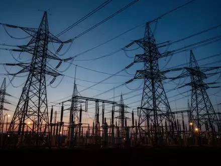 Hochspannungsmasten einer elektrischen Schaltanlage vor einem blauen Abendhimmel als Symbol für kritische Infrastruktur. - Foto: über boerse-global.de