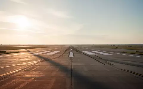 Eine weitläufige, leere Landebahn auf einem Flugplatz während der Dämmerung unter einem weiten Himmel. - Foto: über boerse-global.de