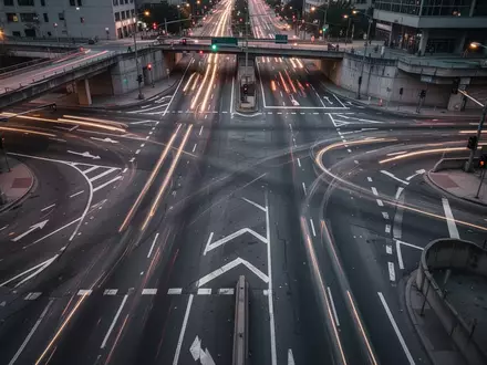 Eine leere urbane Straßenkreuzung bei Dämmerung mit komplexen Fahrbahnmarkierungen und städtischer Infrastruktur. - Foto: über boerse-global.de