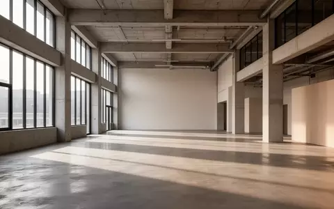 Ein minimalistischer, leerer Industrieraum mit hohen Decken und natürlichem Lichteinfall, der eine offene Atmosphäre vermittelt. - Foto: über boerse-global.de