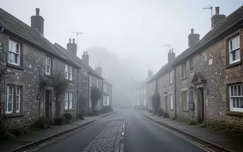 Eine menschenleere, ruhige Dorfstraße in einer ländlichen Region Englands bei nebligem Morgenlicht. - Foto: über boerse-global.de