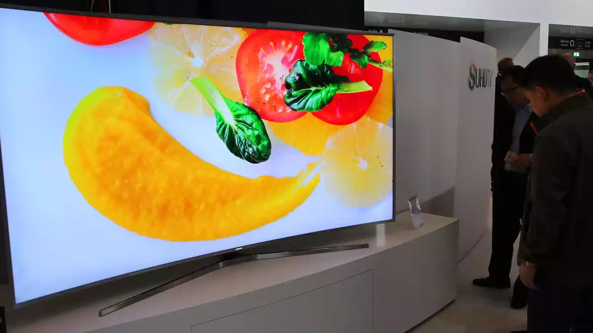 Besucher betrachten auf der IFA 2015 hochauflösende gebogene Flachbildschirme von Samsung. - Bild: Wolfgang Kumm/dpa