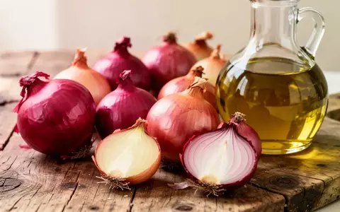 Frische Zwiebeln und eine Glasflasche mit Olivenöl auf einer rustikalen Holzoberfläche. - Foto: über boerse-global.de