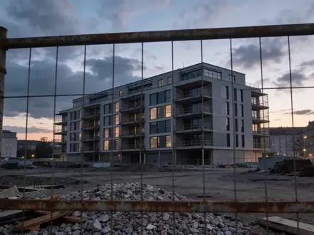 Eine verlassene Baustelle mit einem im Bau befindlichen Wohnkomplex in der Abenddämmerung. - Foto: über boerse-global.de