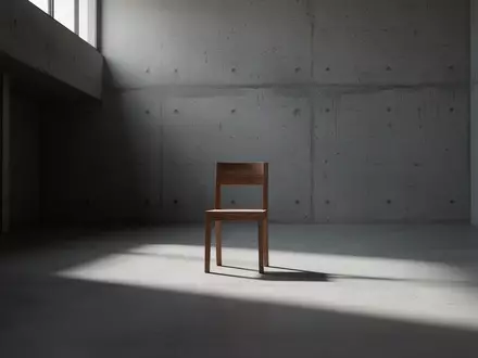 Ein minimalistischer, leerer Raum mit einem einzelnen Holzstuhl und langen Schatten bei natürlichem Lichteinfall. - Foto: über boerse-global.de
