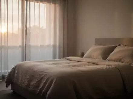 Ein minimalistisches, ruhiges Schlafzimmer im sanften Licht der Morgendämmerung, das Erholung und Regeneration symbolisiert. - Foto: über boerse-global.de