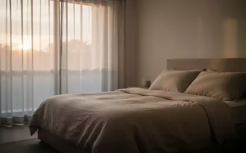 Ein minimalistisches, ruhiges Schlafzimmer im sanften Licht der Morgendämmerung, das Erholung und Regeneration symbolisiert. - Foto: über boerse-global.de
