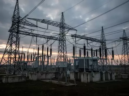 Hochspannungstransformatoren und Strommasten einer Umspannstation in einer ländlichen Umgebung bei Dämmerung. - Foto: über boerse-global.de