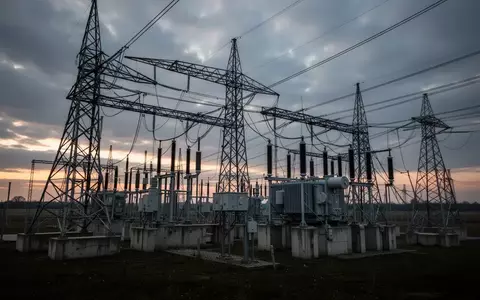 Hochspannungstransformatoren und Strommasten einer Umspannstation in einer ländlichen Umgebung bei Dämmerung. - Foto: über boerse-global.de