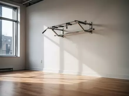 Leere, minimalistische Fitnessumgebung mit einer schlichten Klimmzugstange an einer weißen Wand. - Foto: über boerse-global.de