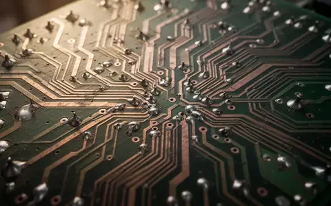 Nahaufnahme einer komplexen Leiterplatte mit detaillierten Kupferbahnen in einer abstrakten, technischen Umgebung. - Foto: über boerse-global.de