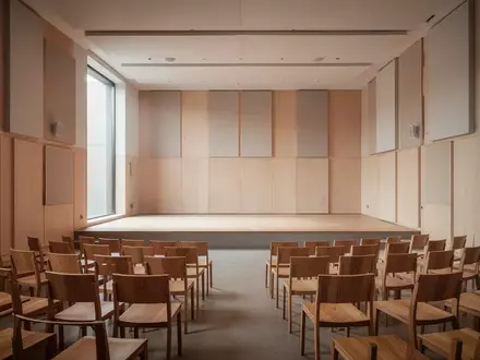 Ein minimalistischer, heller Forschungsraum mit Holz-Akustikpaneelen und einer symmetrischen Anordnung von Stühlen. - Foto: über boerse-global.de
