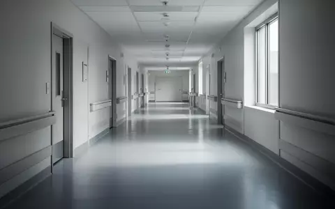 Ein leerer, modern gestalteter Krankenhausflur mit hellen Wänden und reflektierendem Bodenbelag. - Foto: über boerse-global.de