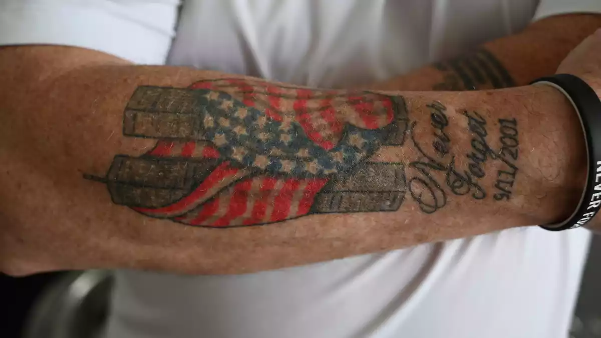Es hat Jahre gebraucht, bis Feuerwehrmann Andrews sich nach 9/11 ein Bild der in eine amerikanische Flagge gehüllten Zwillingstürme auf den Unterarm tätowieren lassen konnte.  - Bild: Anne Pollmann/dpa