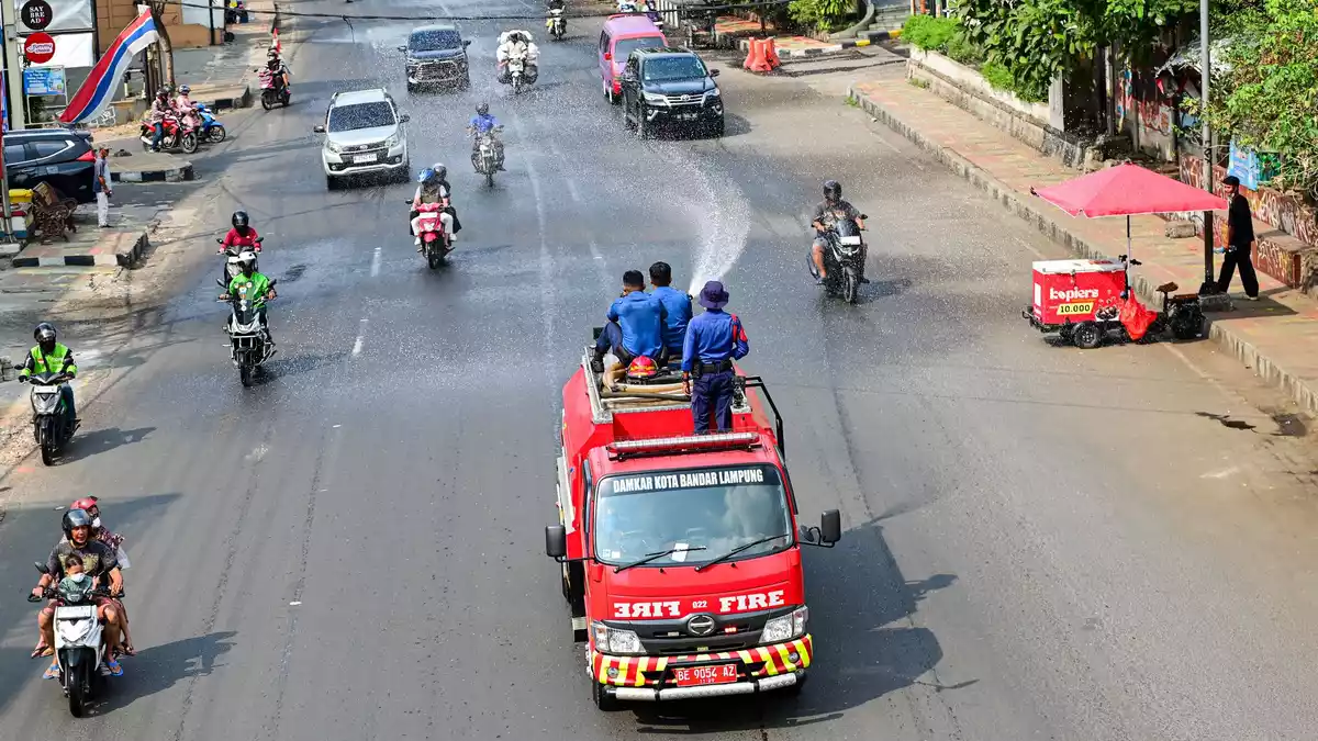 Die Feuerwehr spritzt Wasser auf die Straßen, um die Staubbelastung zu verringern.  - Bild: Wauntara/AP/dpa