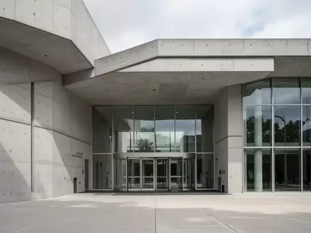 Ein minimalistisches, modernes Regierungsgebäude mit klaren Betonstrukturen und großen Glasfronten bei Tageslicht. - Foto: über boerse-global.de