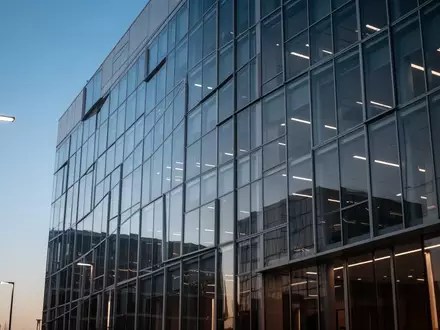 Moderne Glas- und Stahlfassade eines Finanzgebäudes in der Abenddämmerung. - Foto: über boerse-global.de