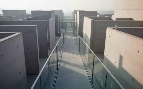 Minimalistische moderne Architektur mit geometrischen Betonwänden und Glasgängen in natürlichem Licht. - Foto: über boerse-global.de