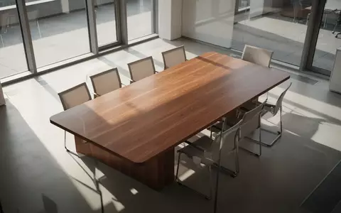 Ein leerer, aufgeräumter Konferenztisch in einem sonnendurchfluteten, modernen Büro mit weichem Tageslicht. - Foto: über boerse-global.de