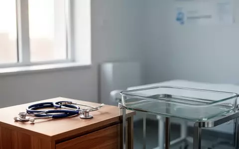 Ein steriler, modern eingerichteter medizinischer Untersuchungsraum mit einem Stethoskop auf einem Holztisch. - Foto: über boerse-global.de