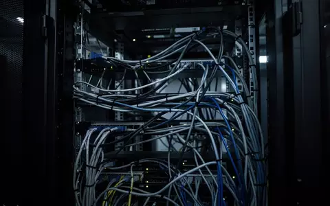 Dunkles Serverraum-Interieur mit komplexem Kabelgewirr und blauer Beleuchtung als Symbol für digitale Kriminalitätsstrukturen. - Foto: über boerse-global.de