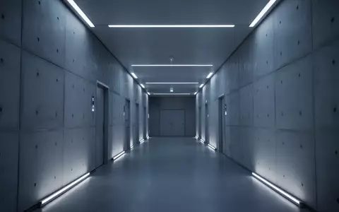 Ein minimalistischer, leerer Flur in einem modernen Forschungszentrum mit bläulichem Umgebungslicht und steriler Architektur. - Foto: über boerse-global.de