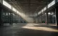 Eine weitläufige, menschenleere Industriehalle mit hohen Decken und Betonboden, die den strukturellen Wandel symbolisiert. - Foto: über boerse-global.de