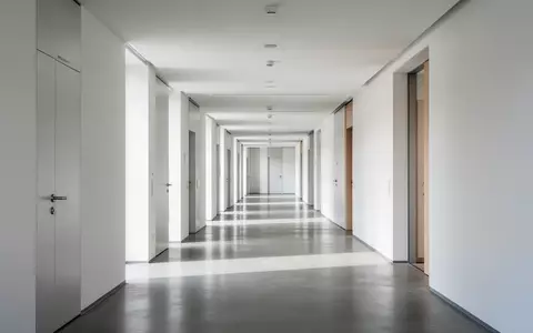 Heller, minimalistischer Flur in einem modernen Verwaltungsgebäude mit klaren architektonischen Linien und Tageslicht. - Foto: über boerse-global.de