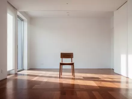 Ein heller, minimalistischer Innenraum mit einem einzelnen Holzstuhl in einem leeren Raum, der von natürlichem Licht durchflutet wird. - Foto: über boerse-global.de