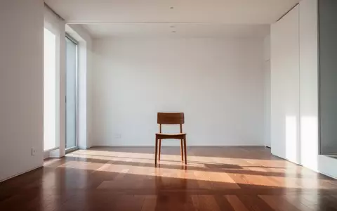 Ein heller, minimalistischer Innenraum mit einem einzelnen Holzstuhl in einem leeren Raum, der von natürlichem Licht durchflutet wird. - Foto: über boerse-global.de