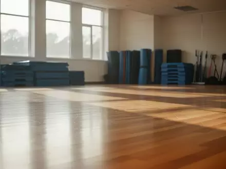 Heller, leerer Gymnastikraum mit Holzboden und einfallendem Tageslicht in einer Sporthalle. - Foto: über boerse-global.de
