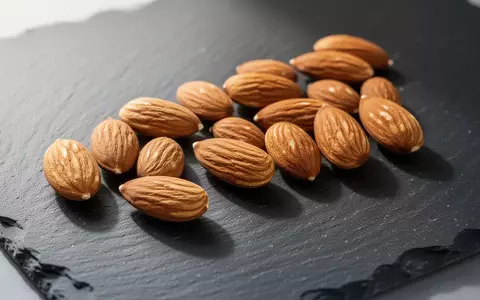 Frische Mandeln auf einer dunklen Schieferplatte als Symbol für gesundheitsbewusste Ernährung zur Blutzuckerregulierung. - Foto: über boerse-global.de