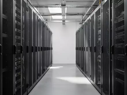 Reihen von leeren Server-Racks in einem modernen, minimalistischen Serverraum bei natürlichem Licht. - Foto: über boerse-global.de