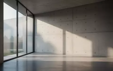 Minimalistischer, moderner Innenraum mit weichem Tageslicht und Schattenwurf an einer Betonwand, der ein Gefühl von Sicherheit und Privatsphäre vermittelt. - Foto: über boerse-global.de