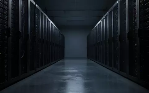 Dunkler Serverraum mit Reihen von industriellen Server-Racks in einer minimalistischen Umgebung. - Foto: über boerse-global.de