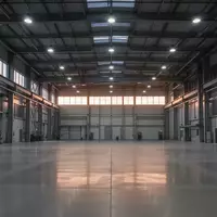 Eine weitläufige, leere Industriehalle mit modernen Betonböden und hohen Fenstern bei Dämmerung. - Foto: über boerse-global.de