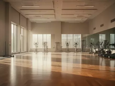 Ein heller, leerer Gymnastikraum mit Holzboden und minimalistischer Ausstattung in einem modernen Sportzentrum. - Foto: über boerse-global.de
