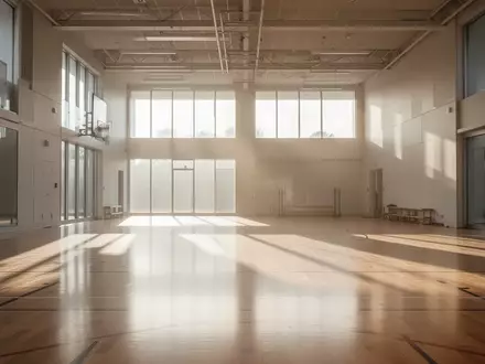 Helle, leere Sporthalle mit poliertem Holzboden und einfallendem Tageslicht. - Foto: über boerse-global.de