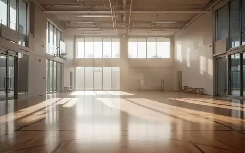 Helle, leere Sporthalle mit poliertem Holzboden und einfallendem Tageslicht. - Foto: über boerse-global.de