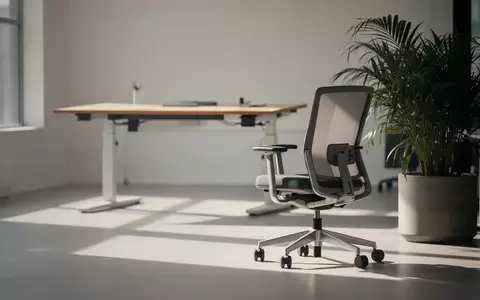 Ein minimalistisches Büro mit einem höhenverstellbaren Schreibtisch und einer Pflanze, die eine Umgebung für ergonomisches Arbeiten darstellt. - Foto: über boerse-global.de