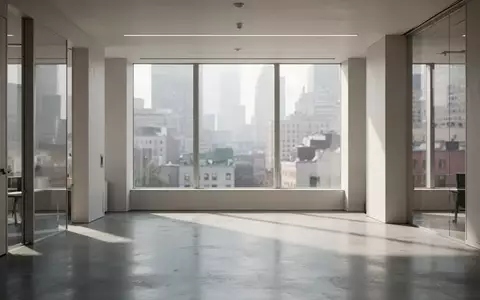 Ein minimalistischer, lichtdurchfluteter moderner Arbeitsraum mit weichem Tageslicht und einer urbanen Stadtlandschaft im Hintergrund. - Foto: über boerse-global.de