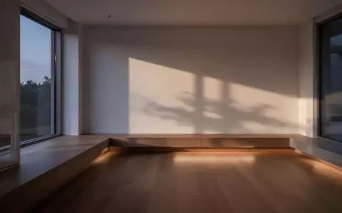 Ein minimalistisch gestalteter, ruhiger Wohnbereich bei Dämmerlicht mit sanftem Lichteinfall und architektonischen Schatten. - Foto: über boerse-global.de