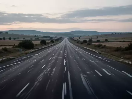 Eine leere, mehrspurige Autobahn in einer ländlichen Umgebung bei Dämmerung. - Foto: über boerse-global.de
