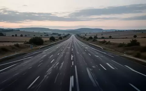 Eine leere, mehrspurige Autobahn in einer ländlichen Umgebung bei Dämmerung. - Foto: über boerse-global.de
