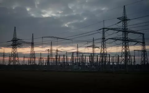 Eine weitläufige Hochspannungs-Umspannanlage in der Dämmerung unter einem bewölkten Himmel. - Foto: über boerse-global.de