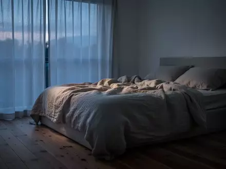 Ein minimalistisch eingerichtetes Schlafzimmer in ruhigem Licht mit neutraler Bettwäsche und natürlicher Atmosphäre. - Foto: über boerse-global.de