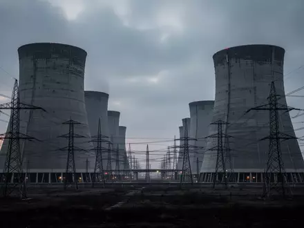 Weitläufiges Industriegelände mit massiven Kühltürmen und Strommasten in der Dämmerung als Symbol für kritische Infrastruktur. - Foto: über boerse-global.de