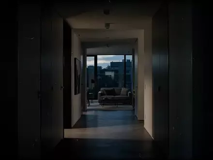 Ein dunkler, minimalistischer Flur in einer Wohnung bei Dämmerung, der eine Atmosphäre von Anspannung vermittelt. - Foto: über boerse-global.de
